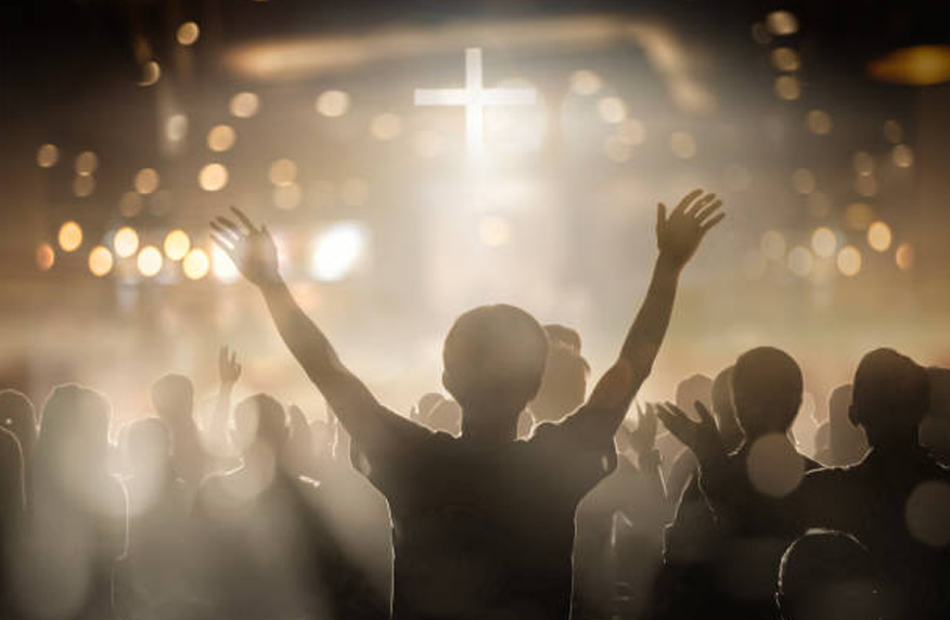 Sunday service on stage — soft azure and amber stage lighting with an attentive congregation